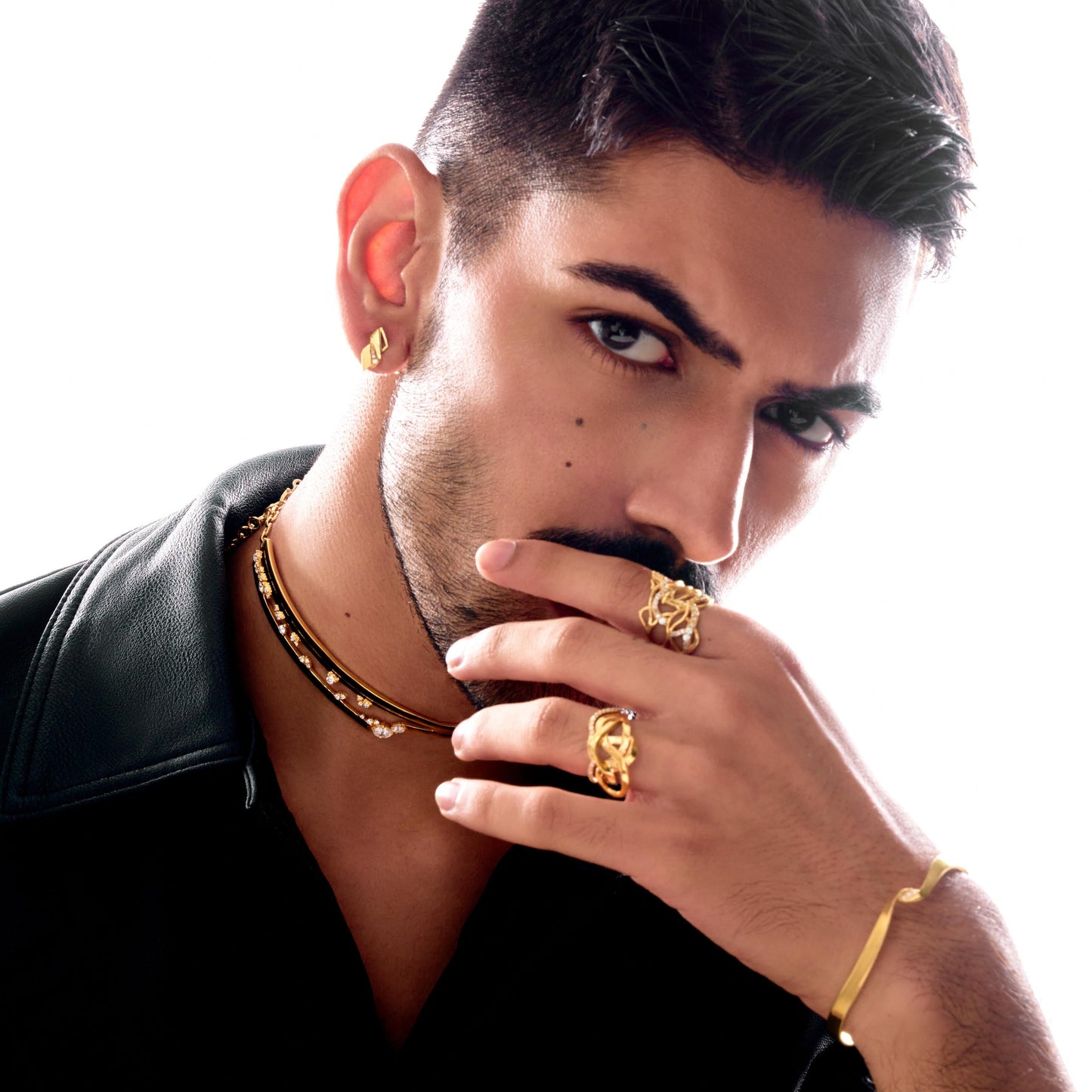 Man wearing gold jewelry against a white background