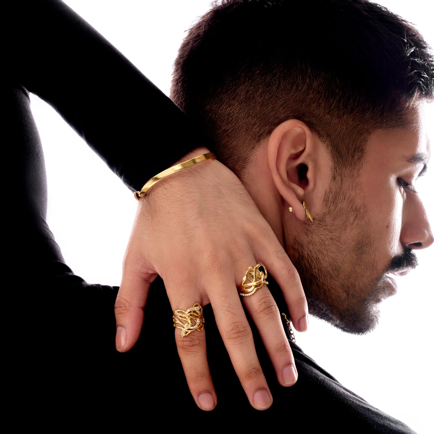 Man wearing gold jewelry with a white background