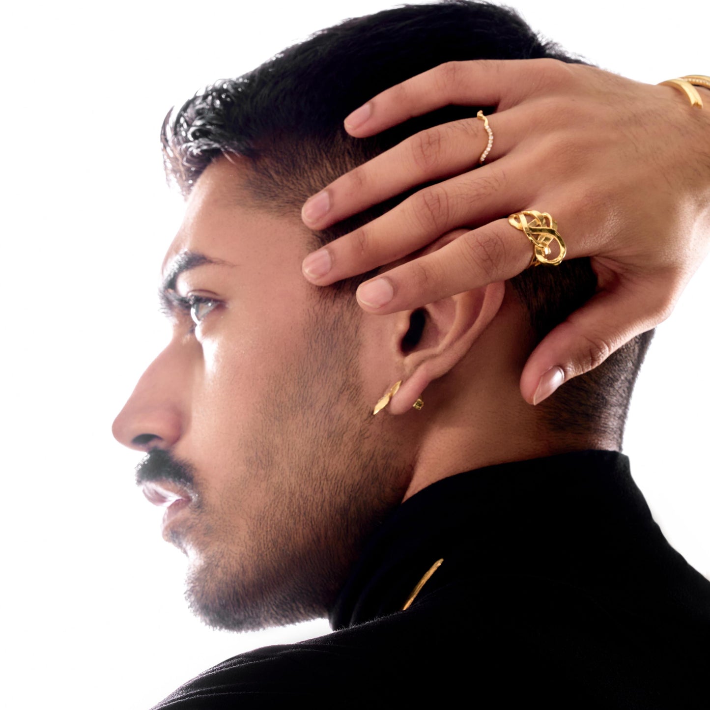 Man with gold jewelry on a white background