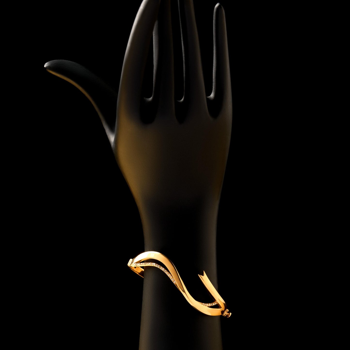 Black mannequin hand holding a gold ring against a black background