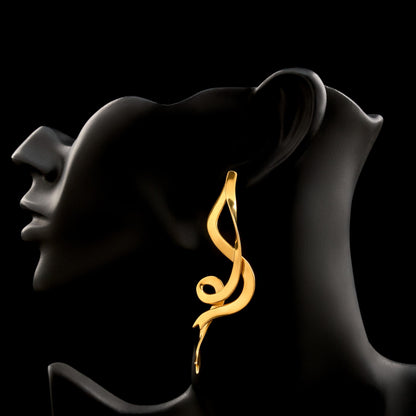 Gold earring on a black silhouette of a person