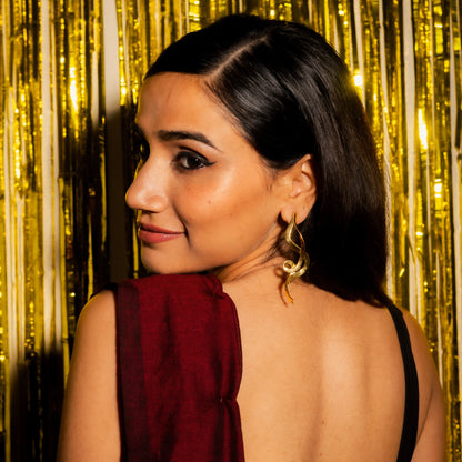 Woman with a backless dress against a gold curtain backdrop