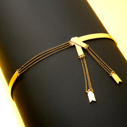 Gold bracelet with hanging charms on a black surface