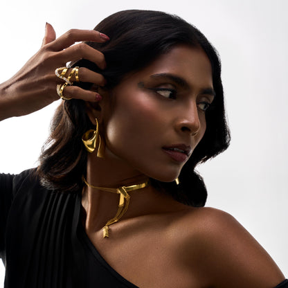 Woman wearing gold jewelry against a white background